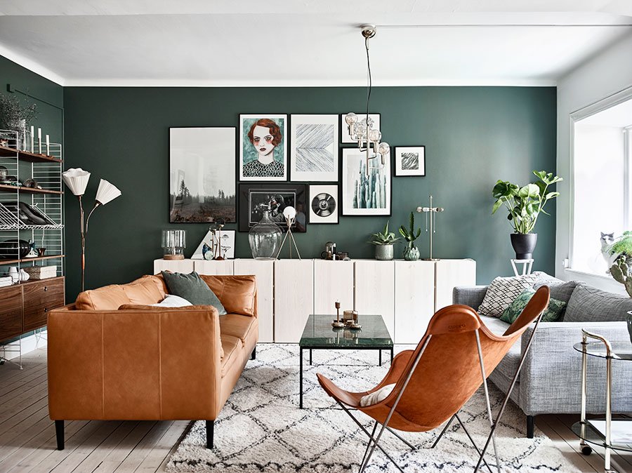 Dark green accent wall of the retro interior of the living room decorated with pictures