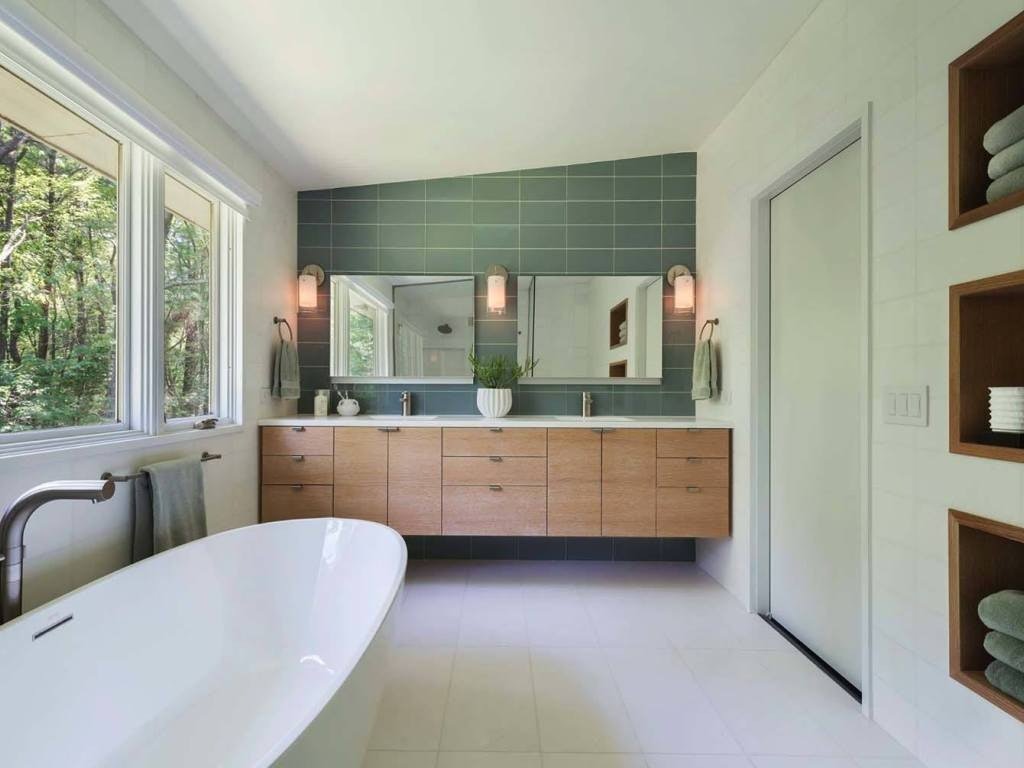 Green shallow tile for modern looking bathroom with large white stone bathtub